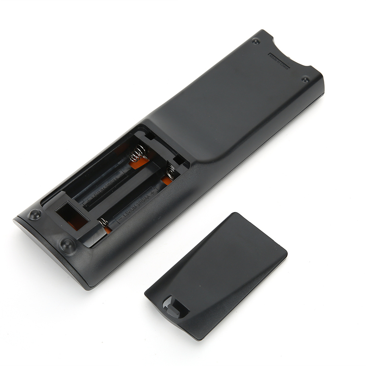 Die Rückseite einer schwarzen Fernbedienung, mit geöffnetem Batteriefach und sichtbaren Batterien.