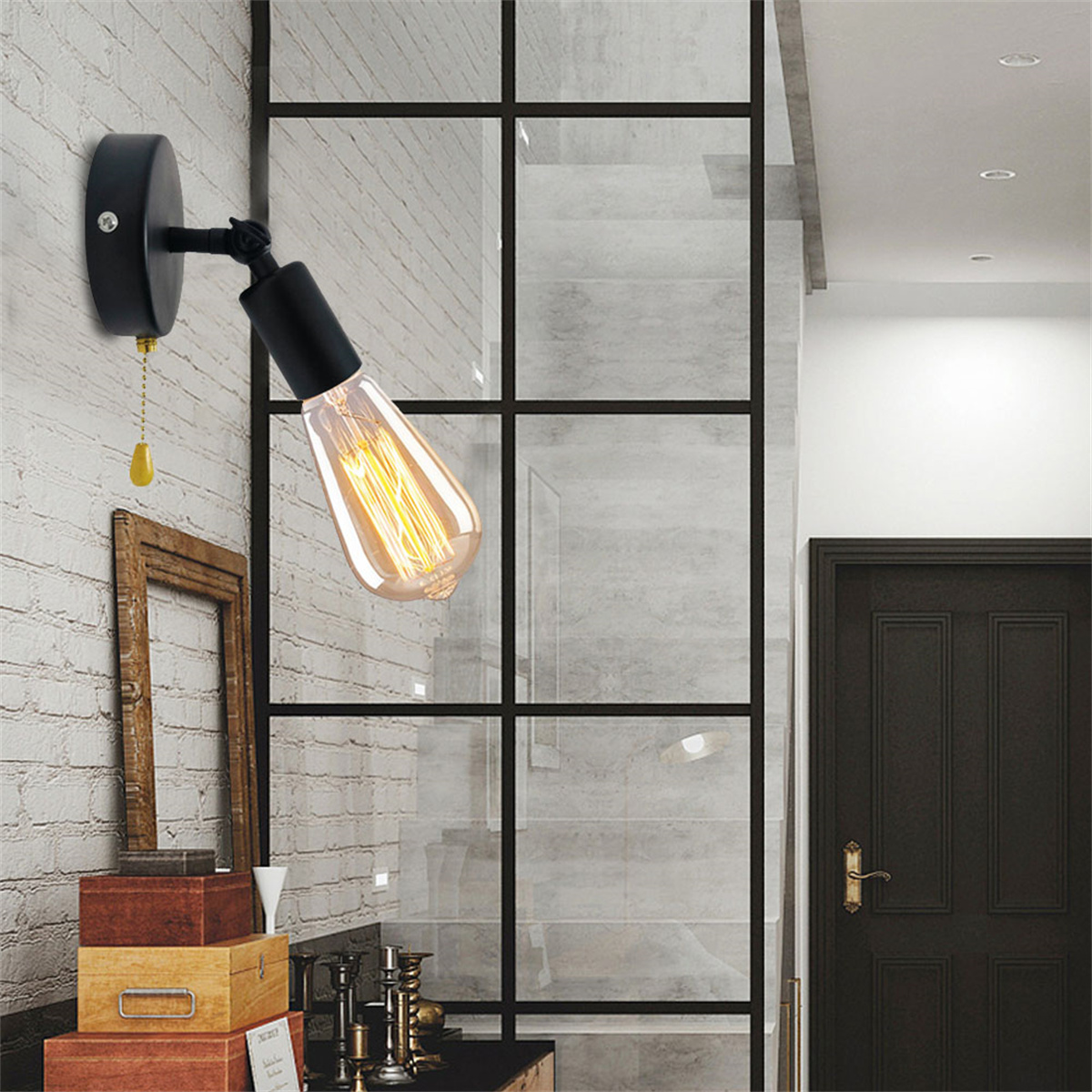 Schwarze Wandlampe mit Glühbirne. Holzkisten im Vordergrund. Innenraum.
