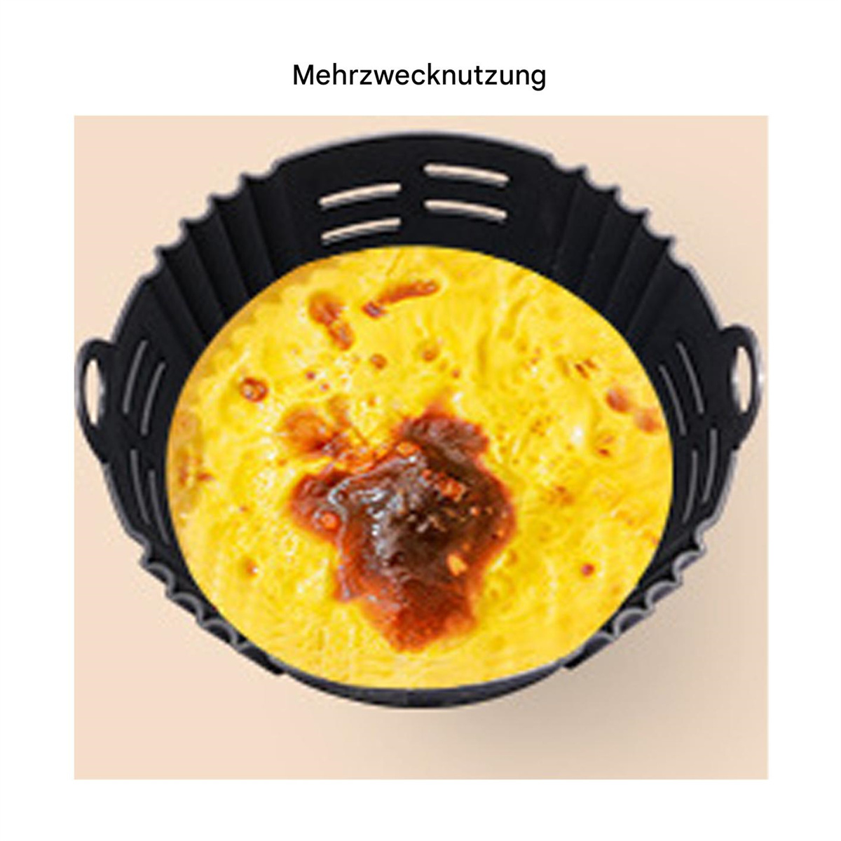 Gelbes Omelett in einem schwarzen Airfryer-Korb, auf beigem Hintergrund.