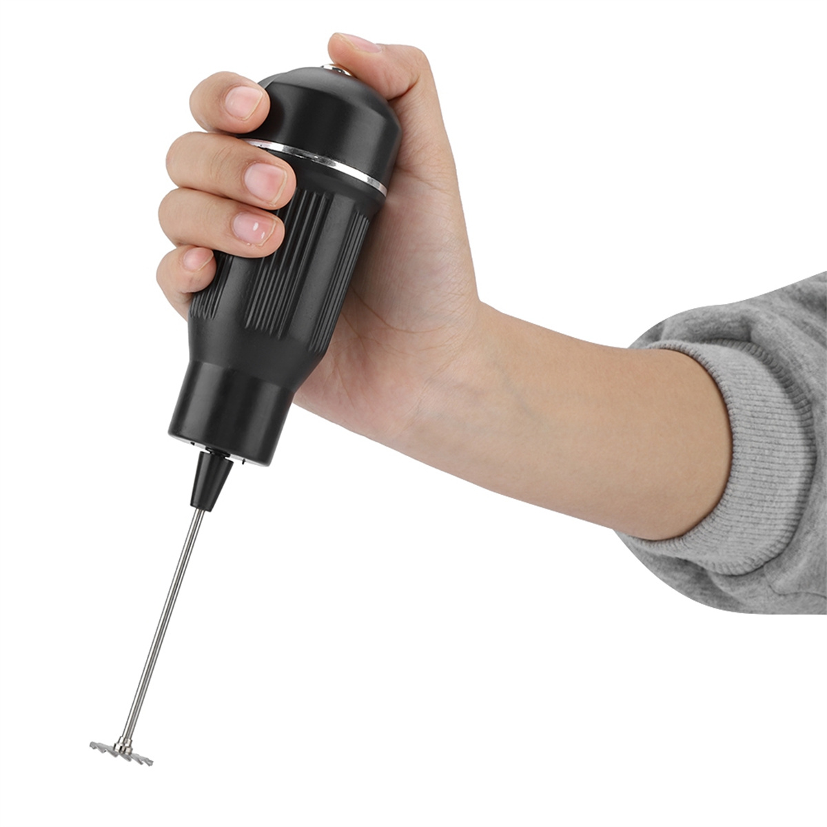 Hand hält einen schwarz-silbernen Milchaufschäumer. Weißer Hintergrund.