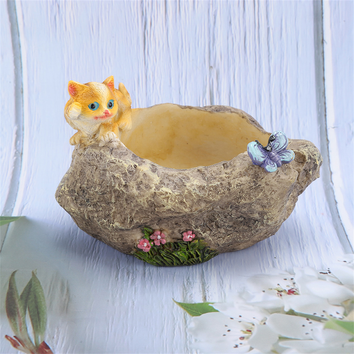 Katzenförmiger Pflanztopf mit Katzen- und Schmetterlingsdetails. Beiger Hintergrund.