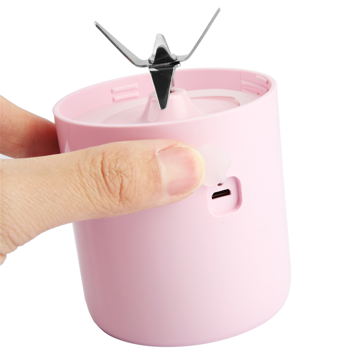 Rosa Mini-Mixer mit Klingen, ein Finger drückt einen Knopf.
