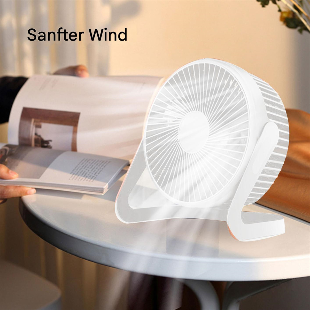 Weißer Ventilator auf einem Tisch, jemand liest ein Buch. Text: Sanfter Wind. Der Ventilator hat einen weißen Hintergrund.