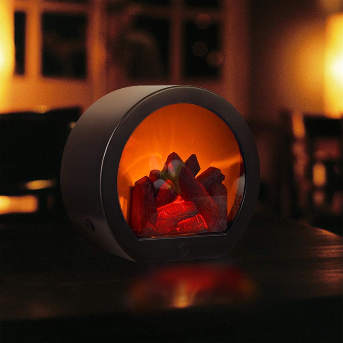 Ein schwarzer Elektro-Kamin mit brennenden Holzscheiten darin, auf einem dunklen Tisch.