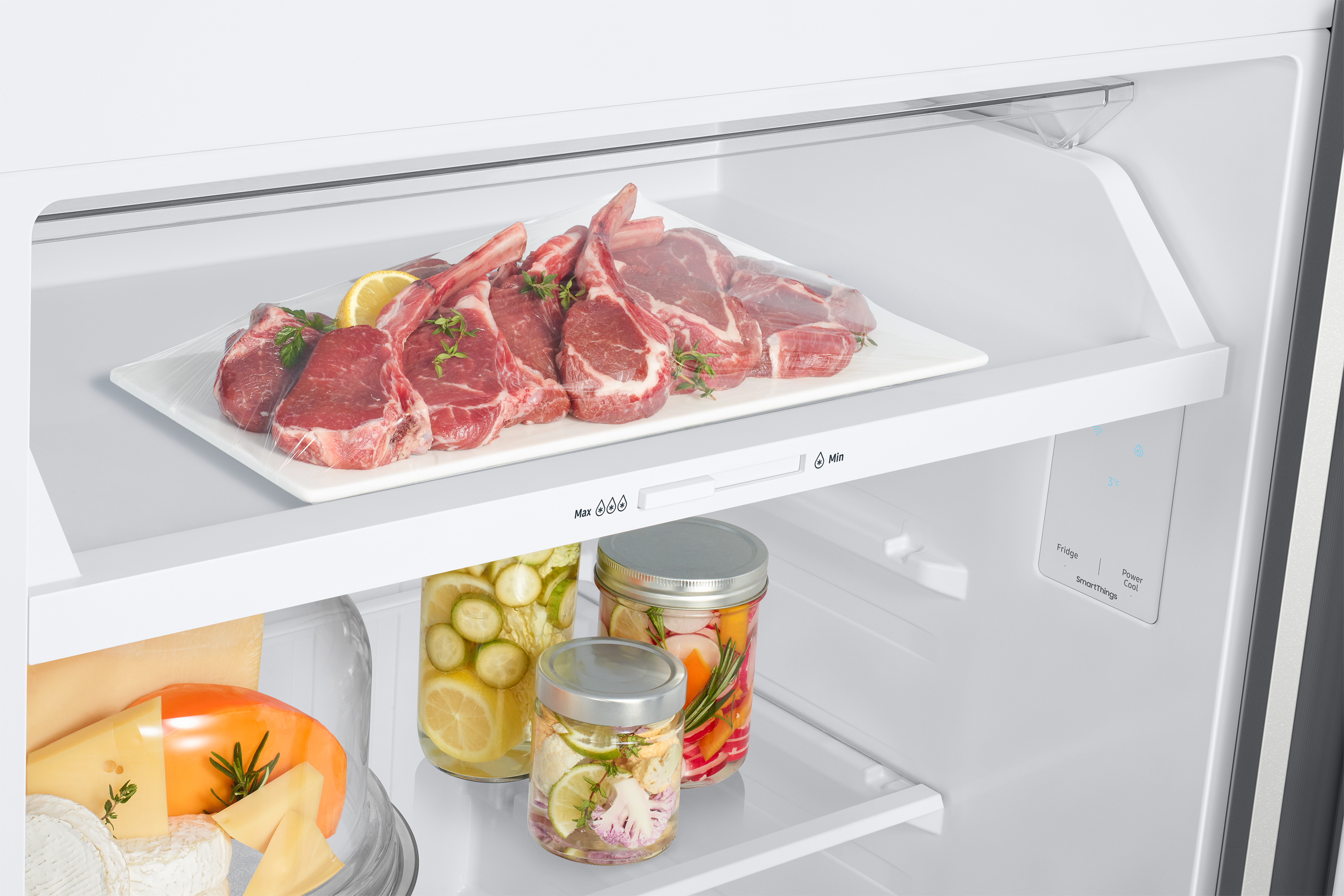 Dentro de un refrigerador con varios alimentos. Chuletas de cordero en un plato, pepinillos y queso.