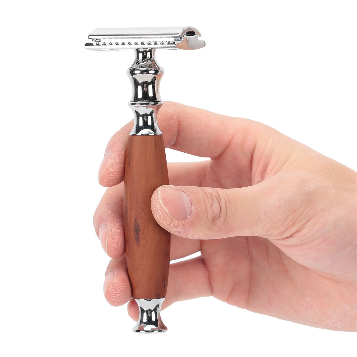 Eine Hand hält einen silber-braunen Rasierer mit Holzgriff, bereit zum Rasieren.