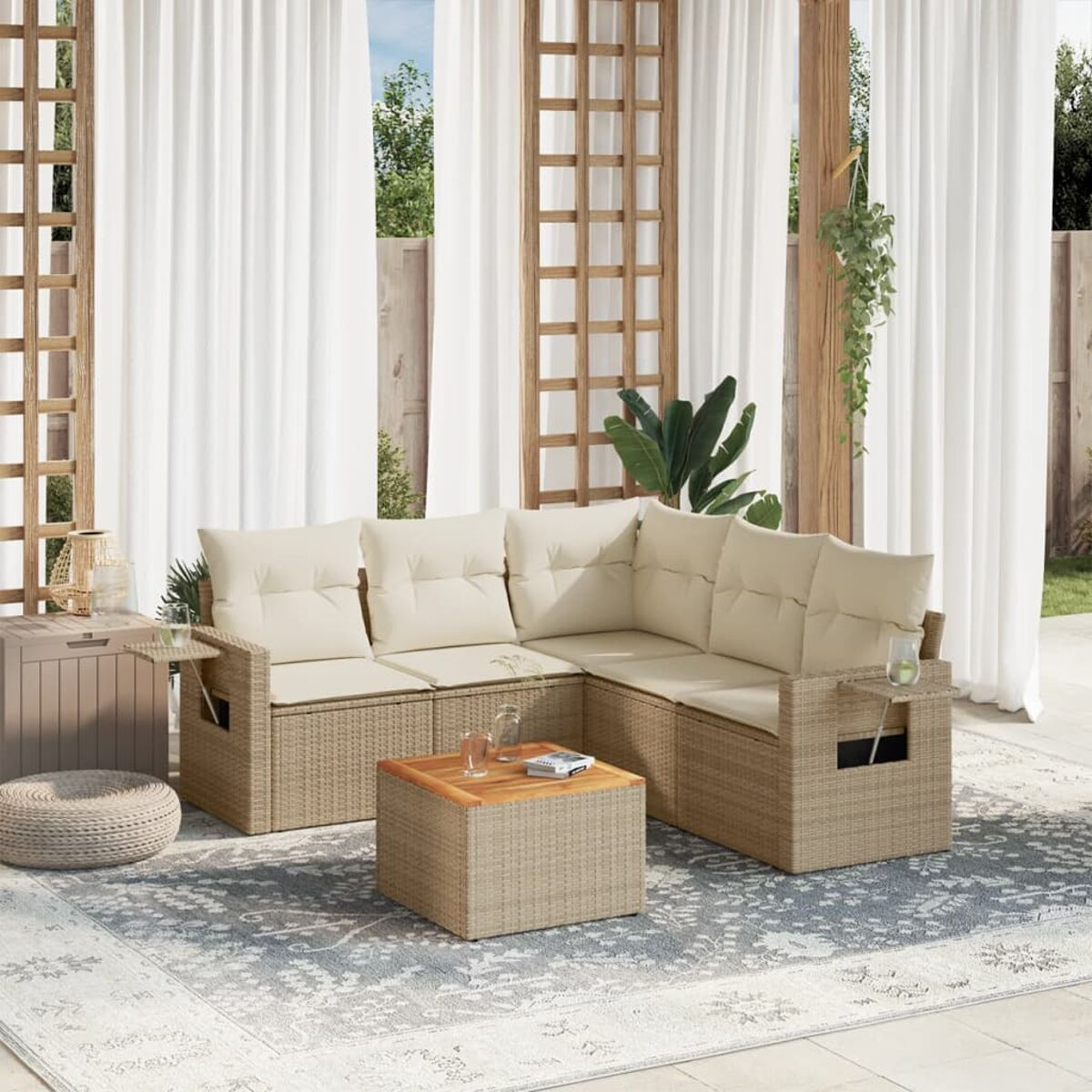 Ein beiges Rattan-Outdoor-Sofa-Set mit Kissen. Es gibt einen Couchtisch und einen Teppich.