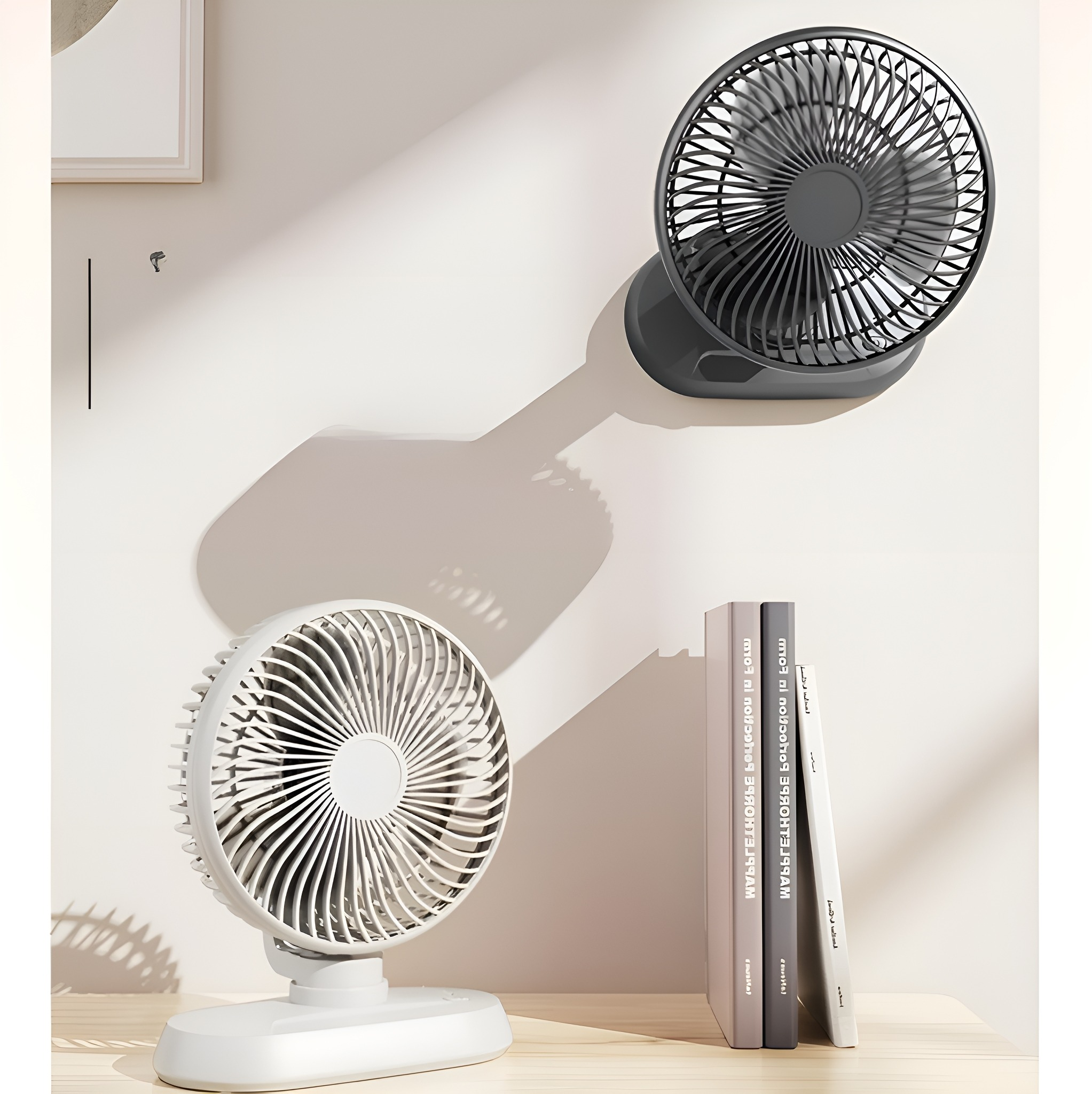 Zwei weiße und graue Ventilatoren an einer Wand und einem Tisch. Bücher sind im Hintergrund.