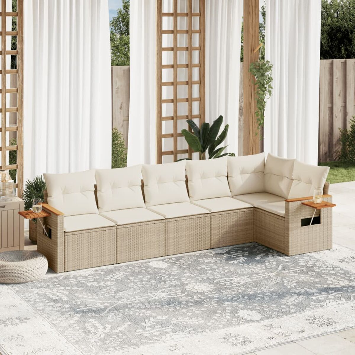 Un divano angolare beige da esterno, un tavolino e un tappeto fantasia.