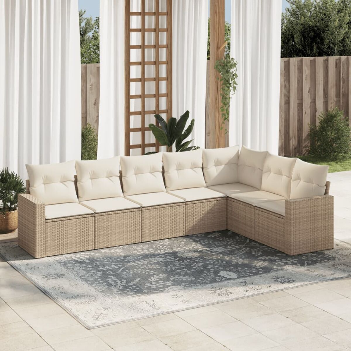 Un set di divani beige per esterni con cuscini bianchi su un tappeto grigio e sfondo.