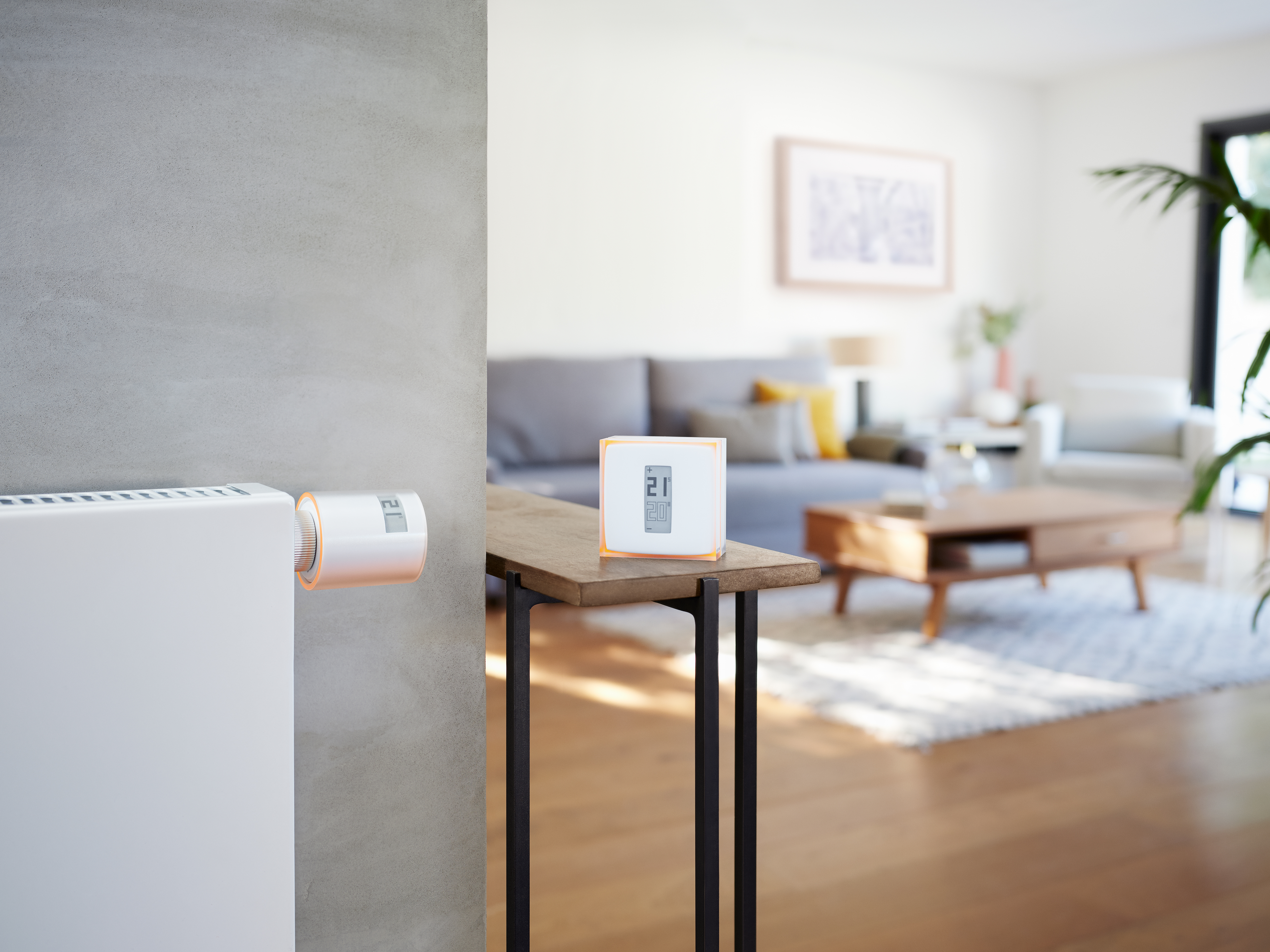 Room with heater and thermostat. Thermostat shows the temperature on the screen.
