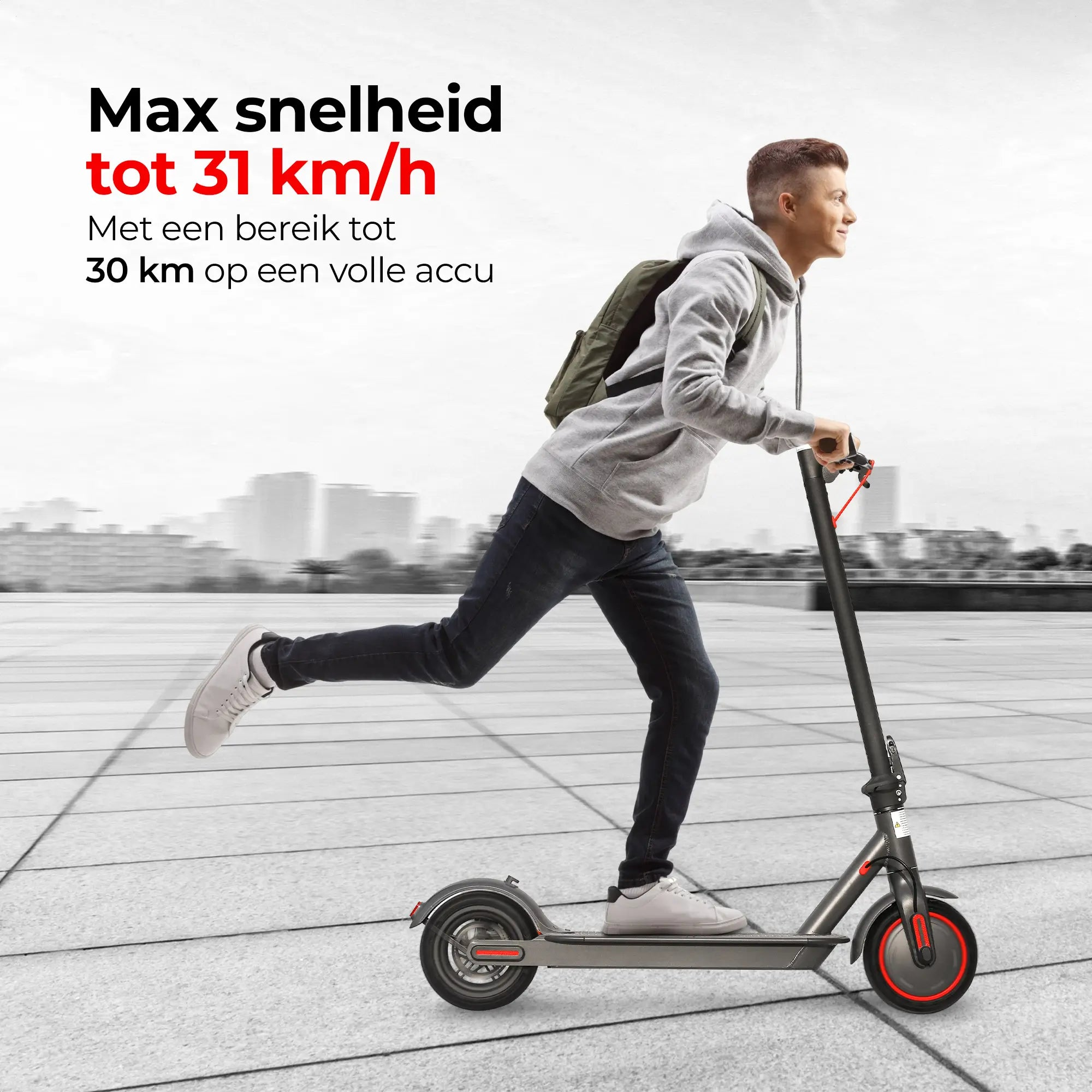 Man riding a scooter on a sidewalk. He wears a gray hoodie and runs with the scooter.