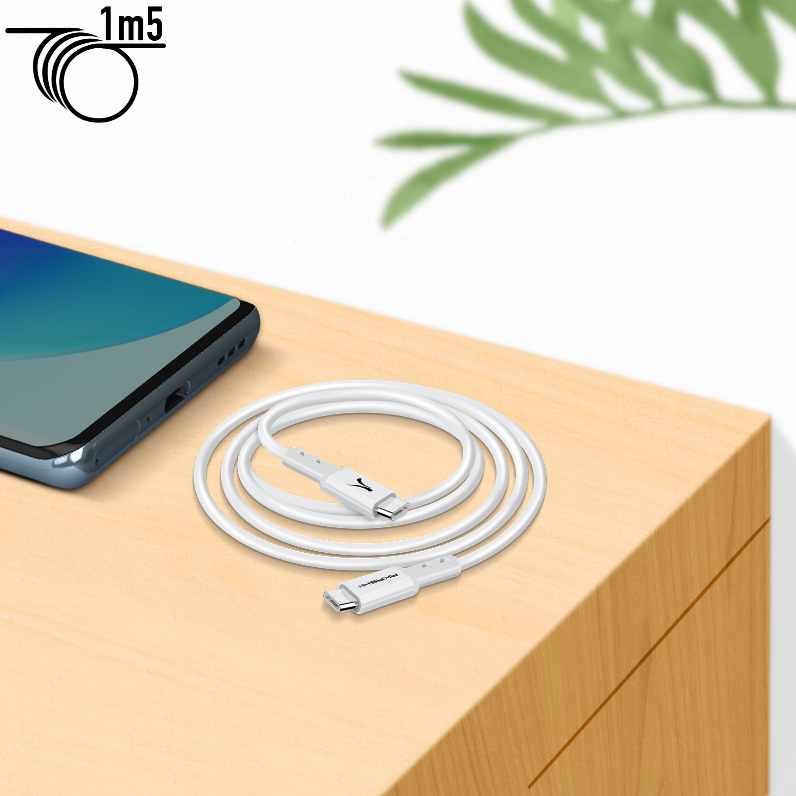 Cavo USB-C bianco arrotolato su superficie in legno, con telefono e foglie sullo sfondo.