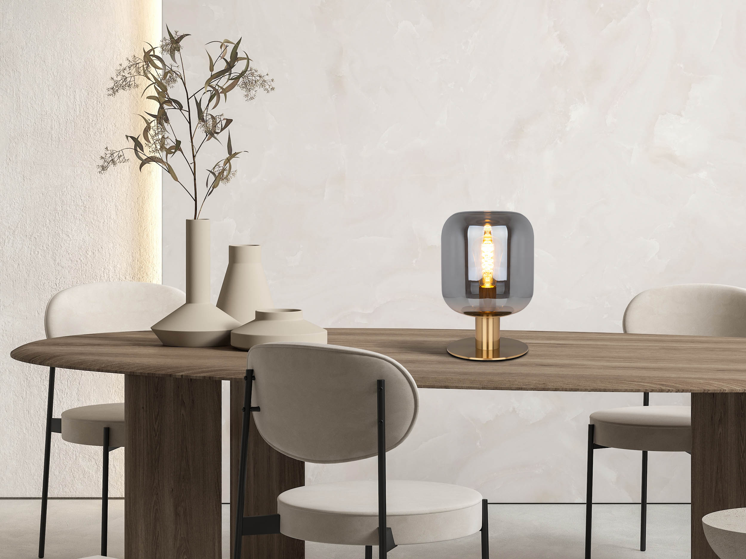 Eine moderne Tischlampe mit grauem Glasschirm und goldenem Sockel.