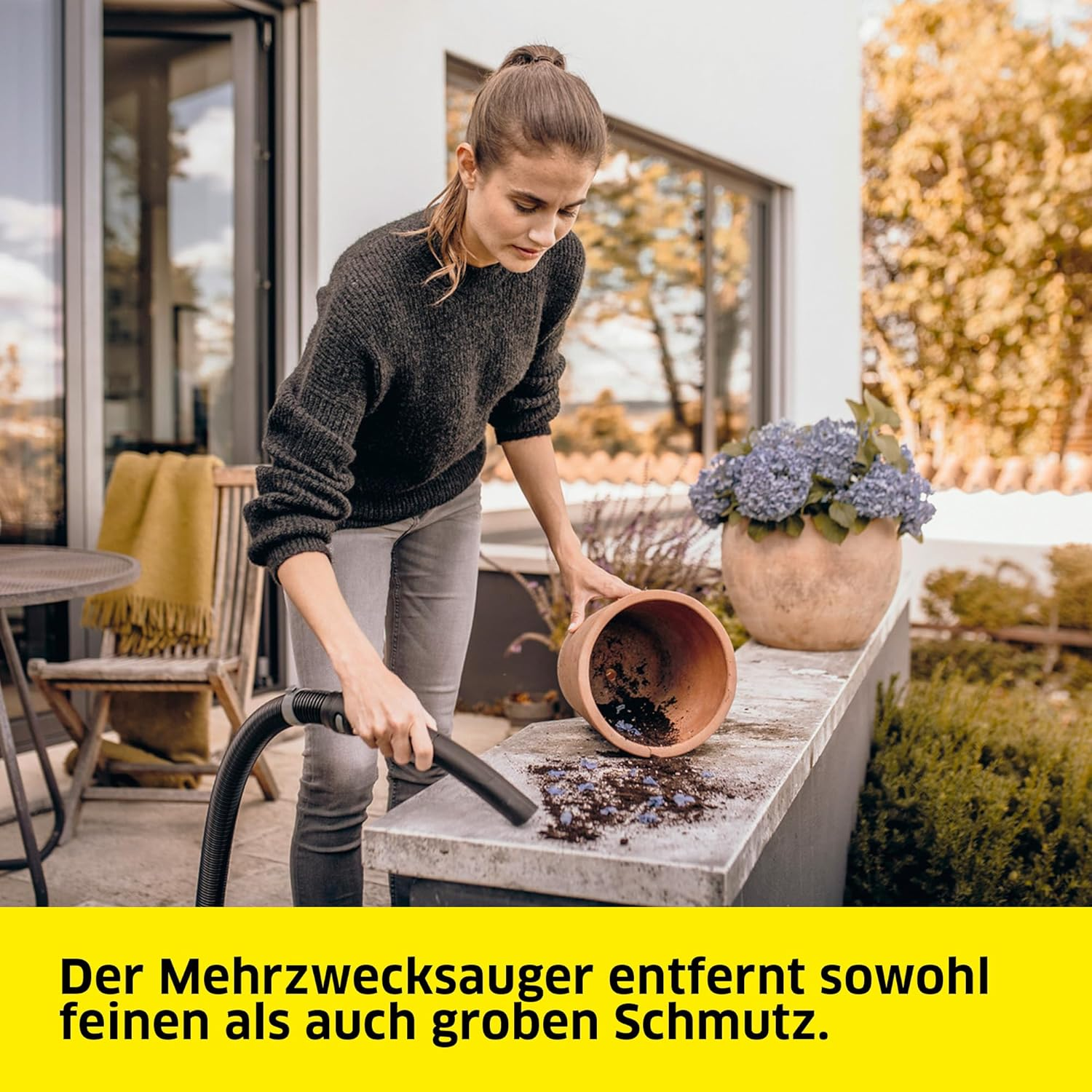 Frau putzt. Frau benutzt einen Staubsauger. Es gibt einen Blumentopf. Text: Der Mehrzwecksauger entfernt sowohl feinen als auch groben Schmutz.