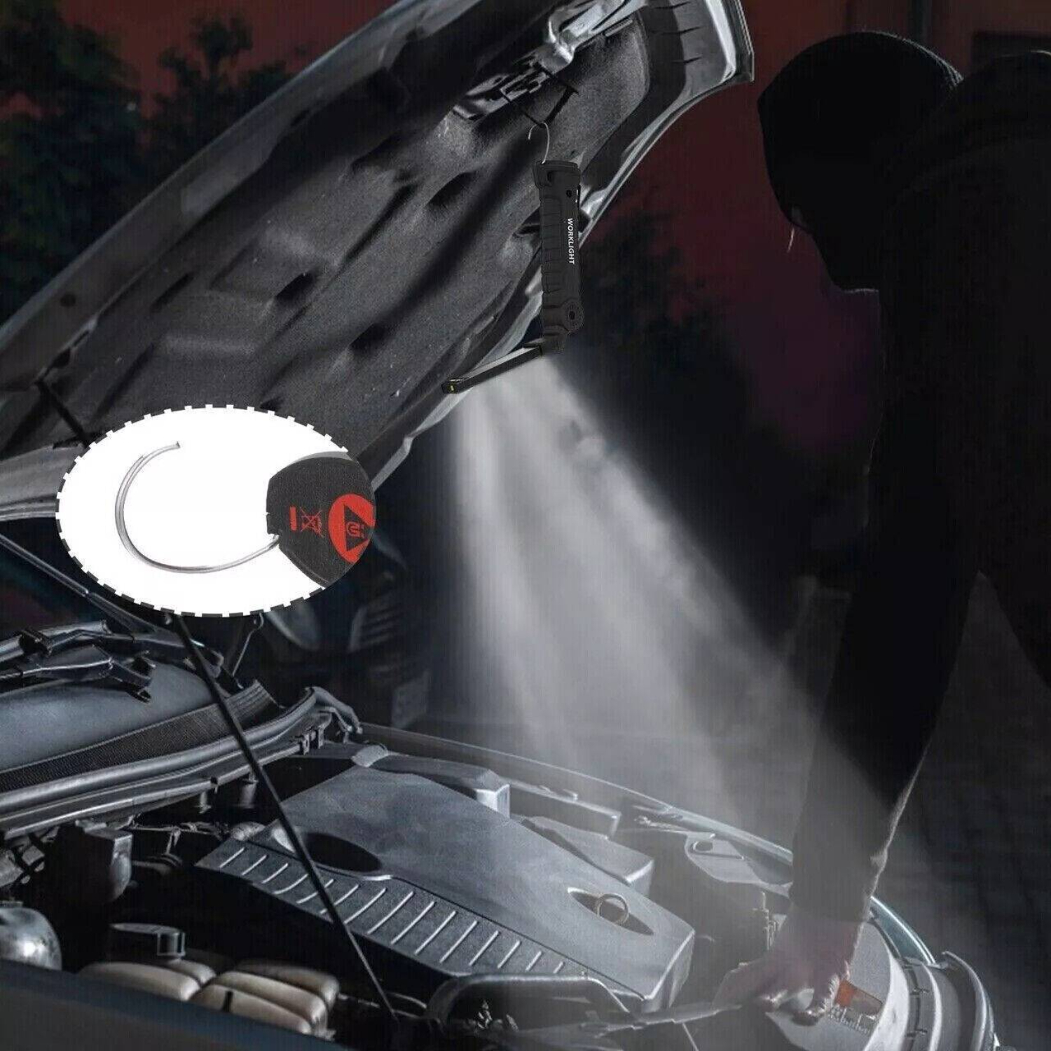 Eine Person in dunkler Kleidung an einem Auto mit offener Motorhaube, Taschenlampenstrahl auf dem Motor.