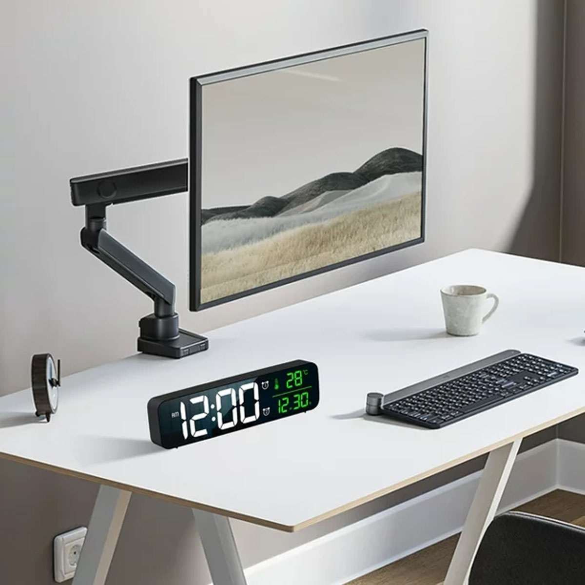 Ein Schreibtisch mit Monitor, Uhr, Tastatur und Becher. Der Monitor ist an einem Arm befestigt.