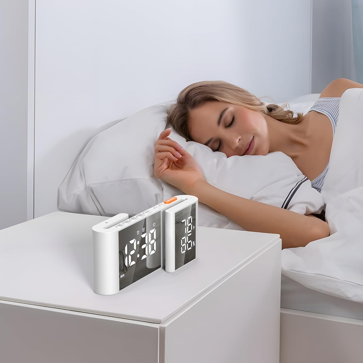Eine schlafende Frau im Bett mit zwei weißen Weckern auf einem Nachttisch.