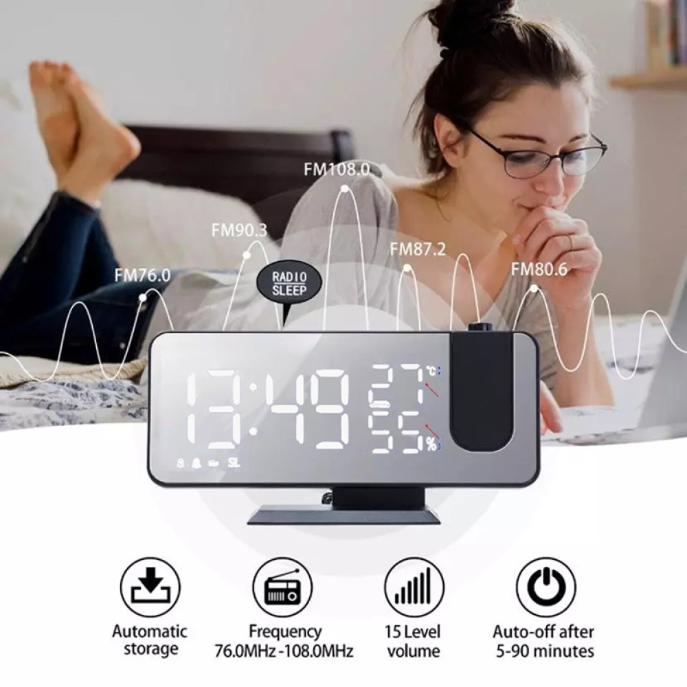 Digitaluhr, die die Zeit anzeigt, mit einer Frau im Hintergrund auf dem Bett.