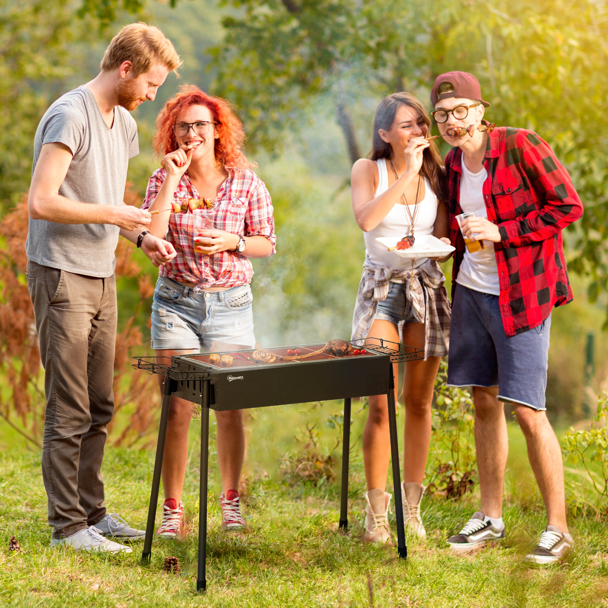 Cuatro personas en una barbacoa. Una persona sostiene un plato, otros comen. Árboles verdes, día soleado.