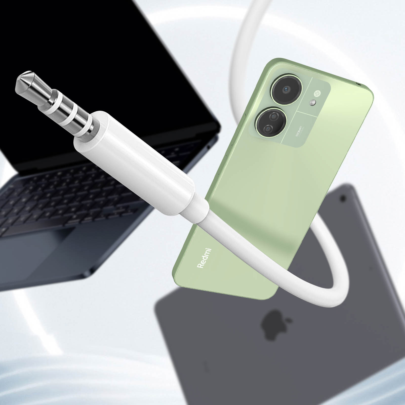 Telefono verde con cavo collegato, un laptop e un tablet sullo sfondo.