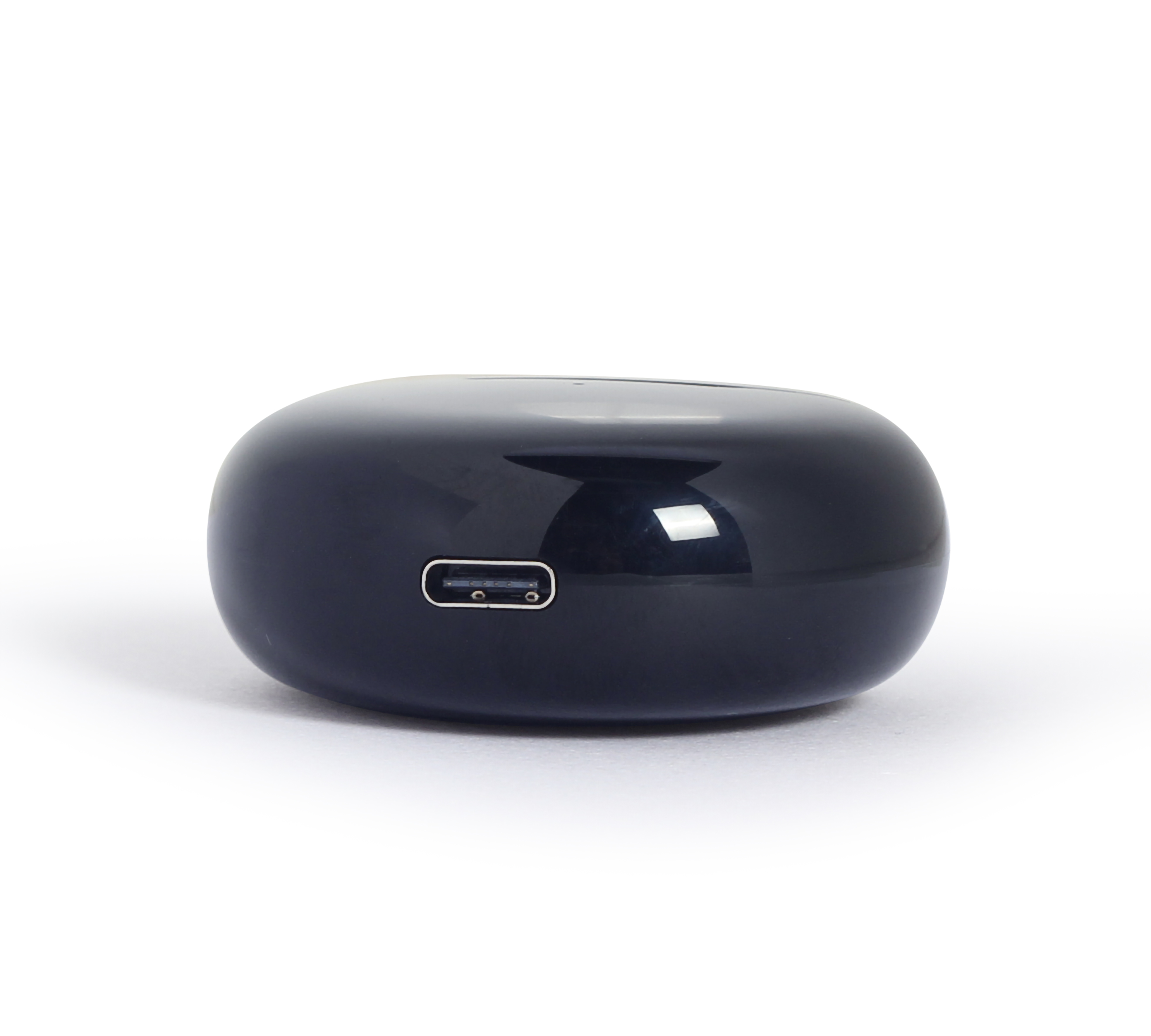 Une station de charge noire, de forme ovale, avec un port USB-C à l'avant.