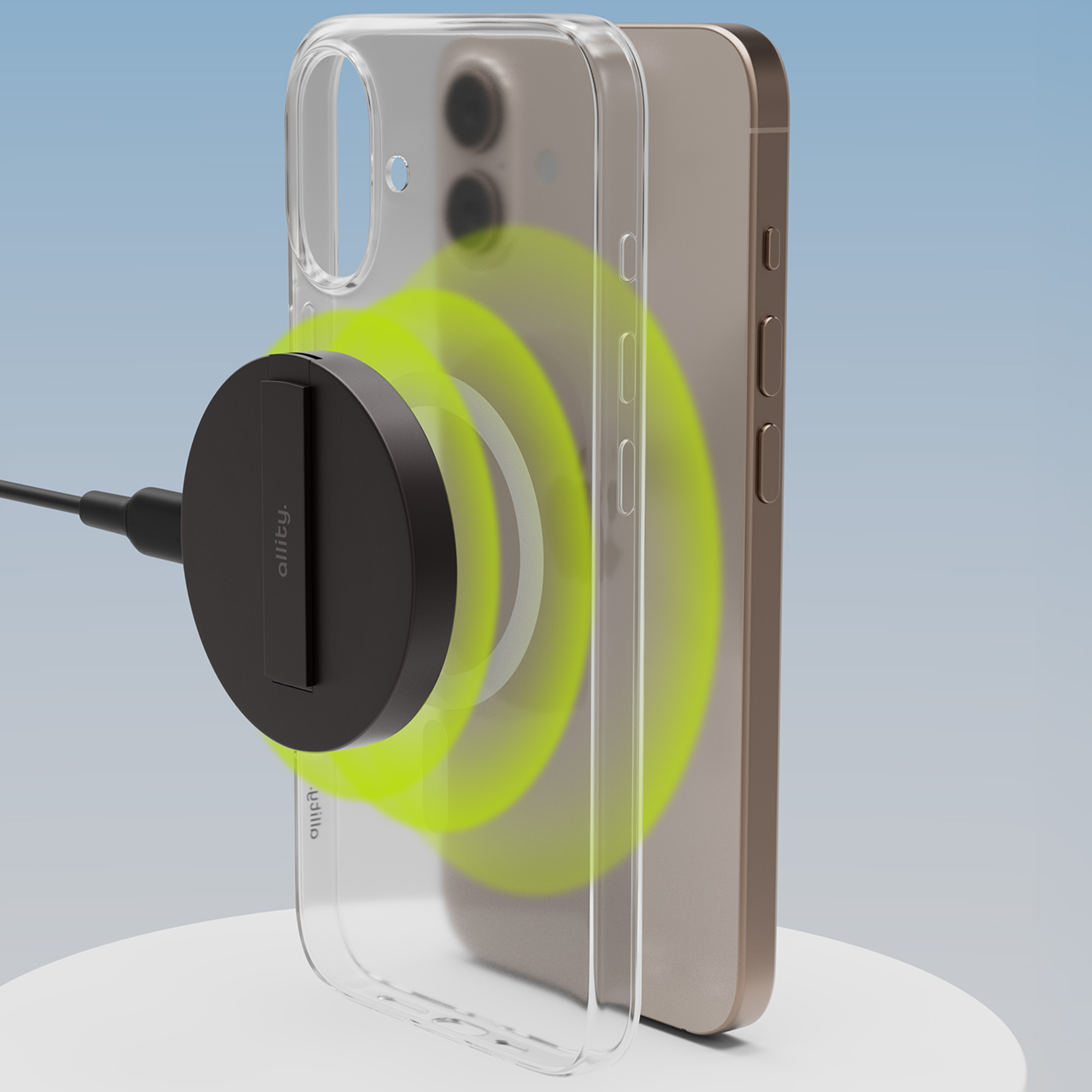 Telefon w przezroczystym etui z dołączoną czarną ładowarką magnetyczną. Ładowarka jest czarna.