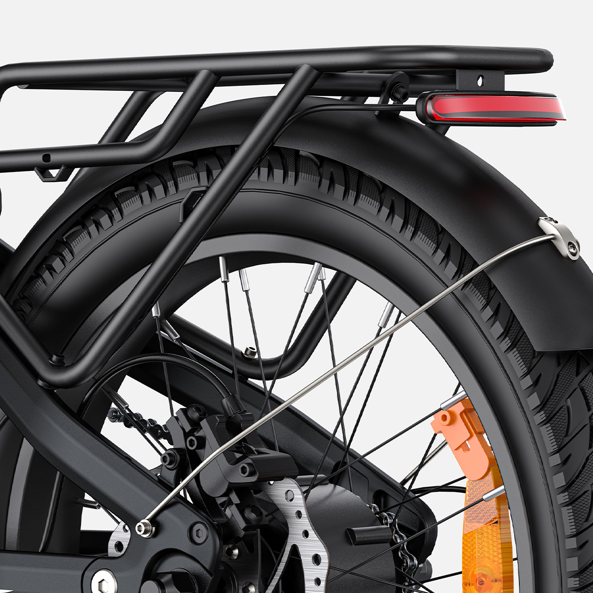 Ruota posteriore di una bicicletta nera, con pneumatico, parafango, portapacchi e catarifrangente rosso.