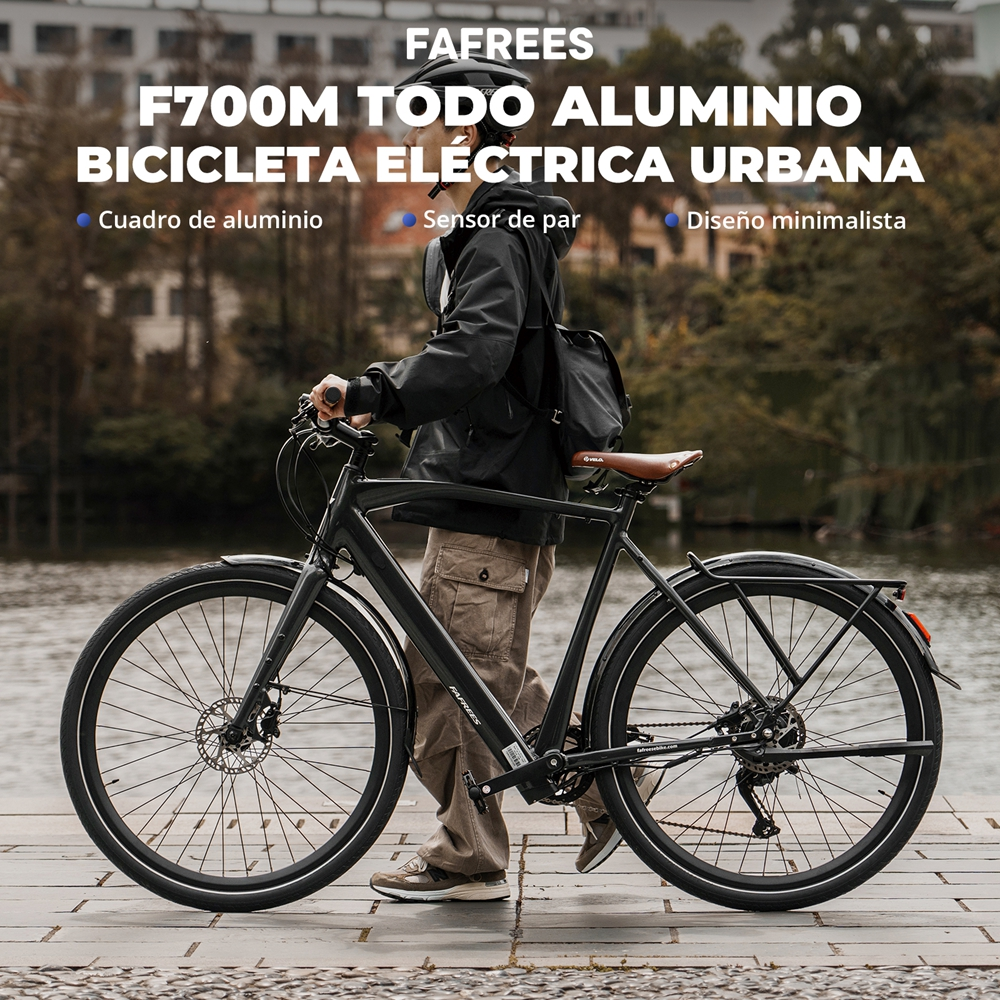 Hombre montando una bicicleta eléctrica negra en una carretera, texto sobre la bicicleta.