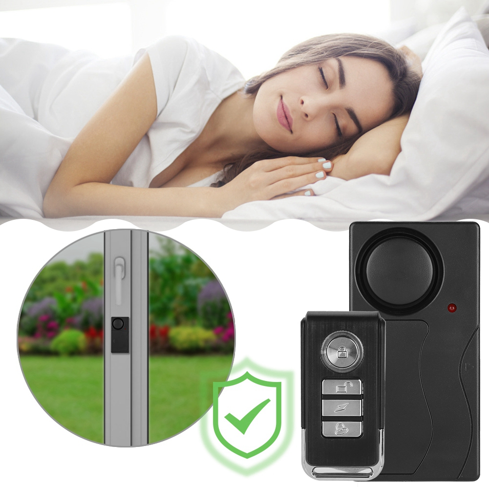 Eine Frau schläft im Bett mit einer Fernbedienung und einem Alarm des Sicherheitssystems. Eine Nahaufnahme eines Türsensors wird gezeigt.