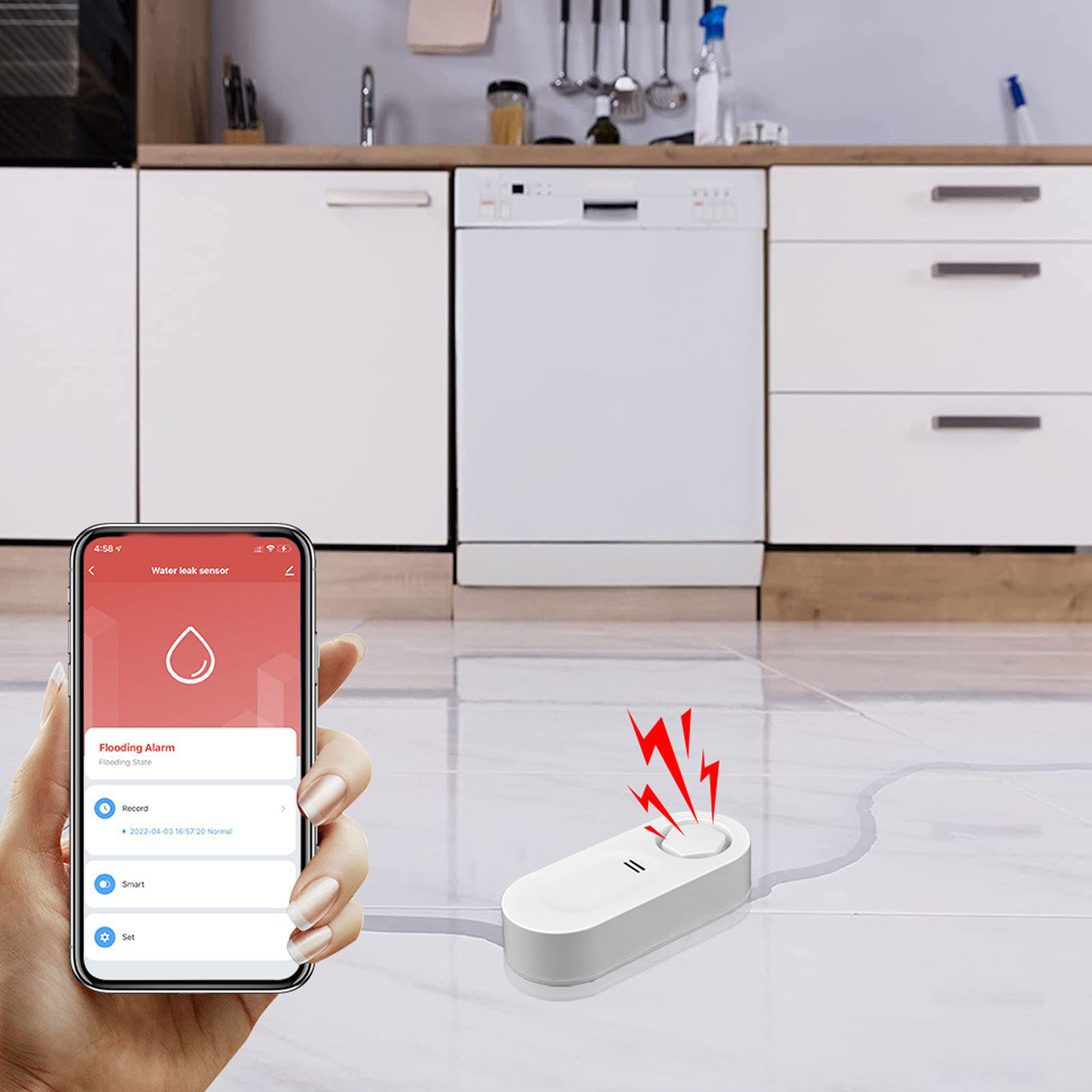 Ein Telefon zeigt einen Wasserlecksensor. Ein weißes Gerät mit roten Alarmen liegt auf dem Boden in der Nähe der Spülmaschine.