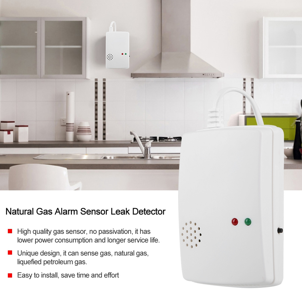 Ein weißer Gasalarm-Sensor mit roten und grünen Lichtern und einem Küchenhintergrund.