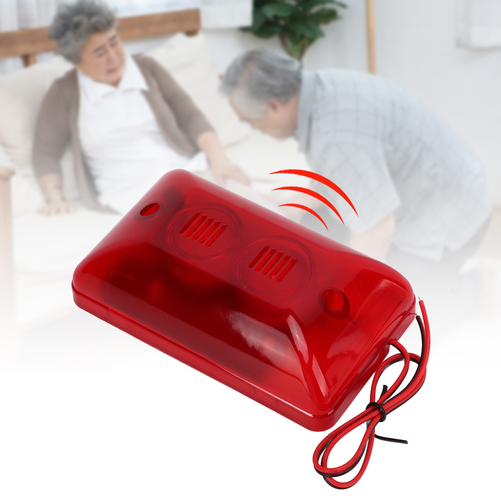 Ein rotes Alarmgerät mit zwei Senioren im unscharfen Hintergrund.