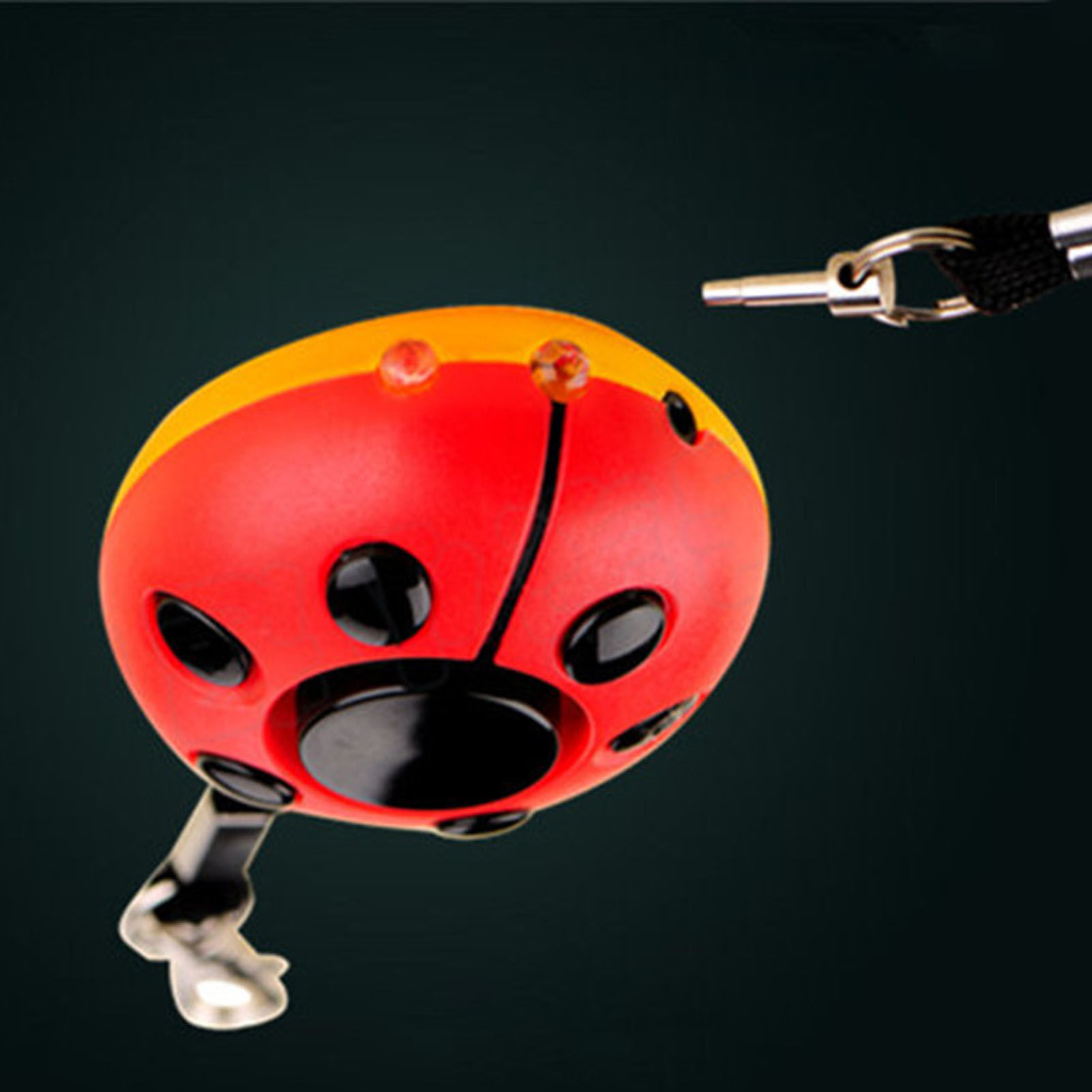 Ein marienkäferförmiges Gerät, rot mit schwarzen Punkten und schwarzem Sockel. Ein Metallschlüssel ist befestigt.