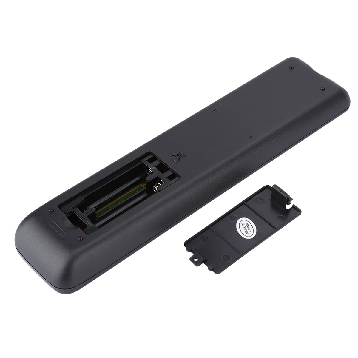 Rückseite einer schwarzen Fernbedienung mit geöffnetem Batteriefach und einer Batterieabdeckung daneben.