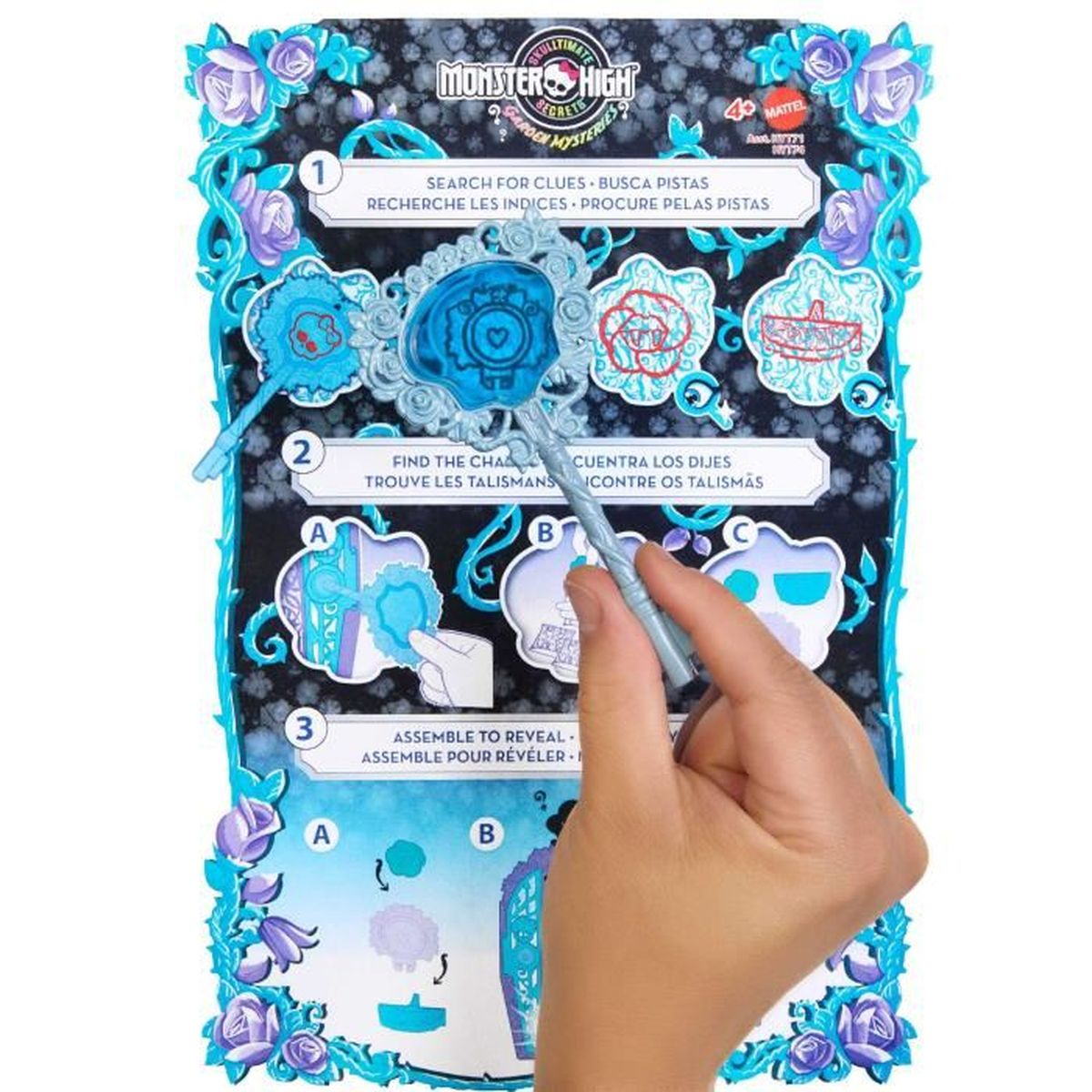 Una mano señala un tablero de juego con instrucciones para un juego de Monster High con recortes de personajes.