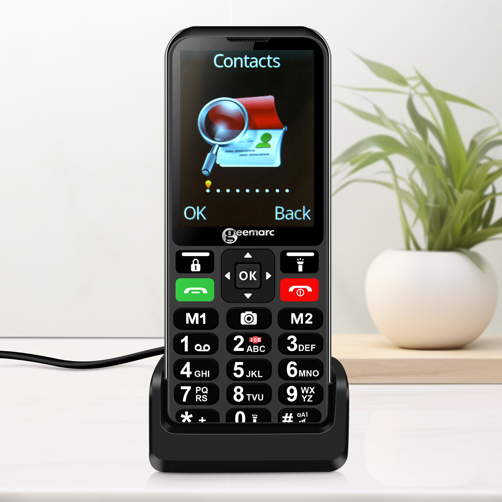 Schwarzes Telefon mit großen Tasten und Ladestation. Kontaktbildschirm auf dem Telefon angezeigt.