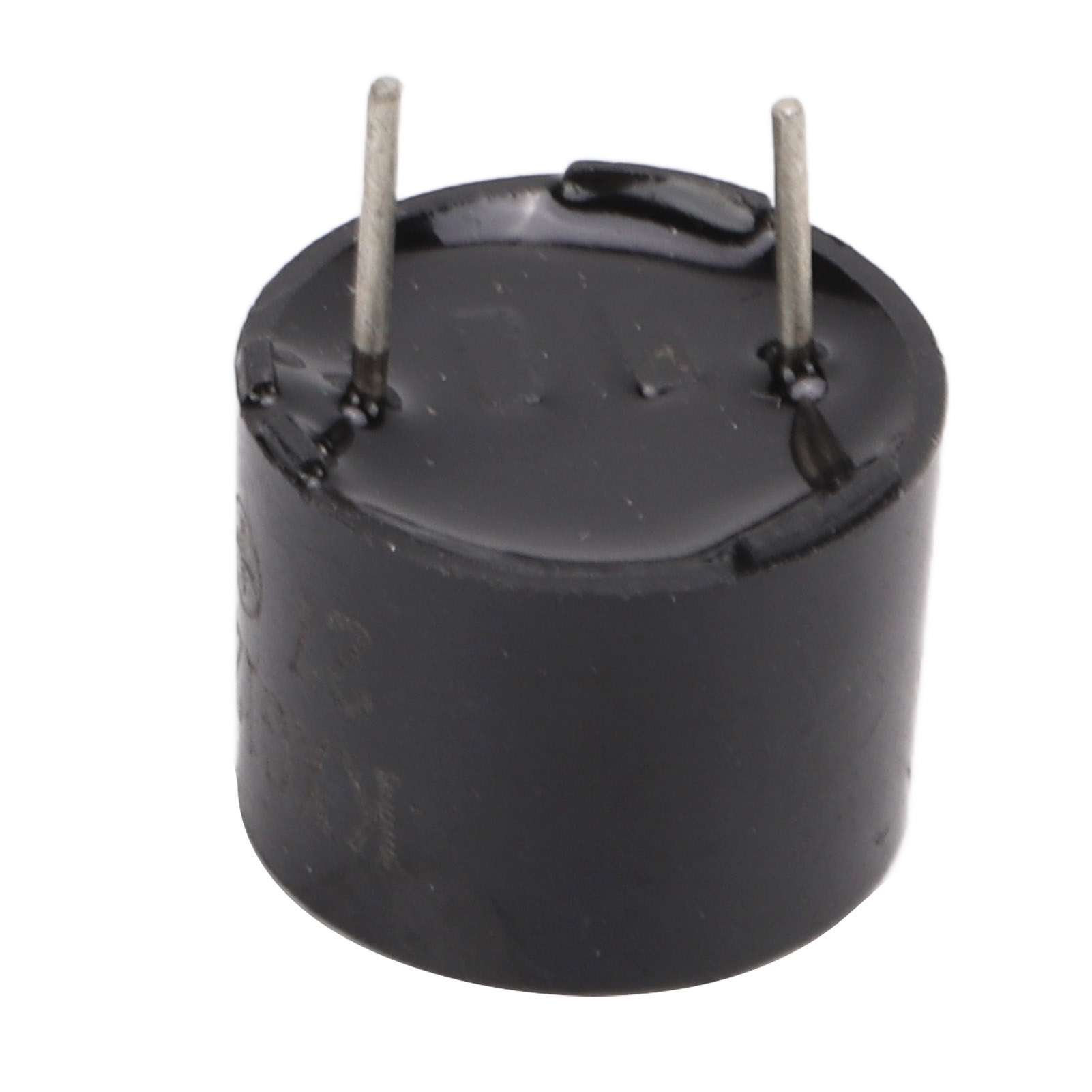 Kleine, schwarze zylindrische Komponente mit zwei metallischen Stiften. Es ist eine Nahaufnahme.