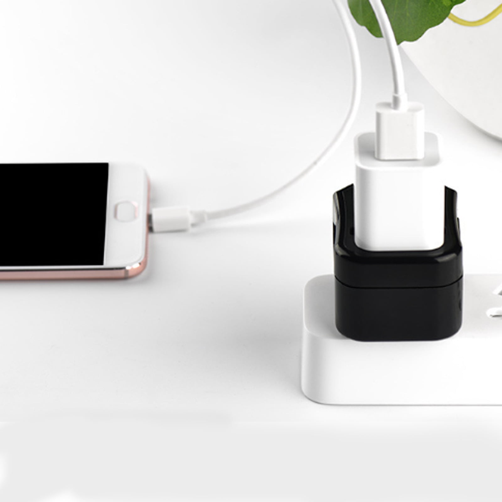 Telefon wird mit weißem Kabel und schwarzem Ladegerät aufgeladen. Das Telefon ist links, das Ladegerät ist im Port.