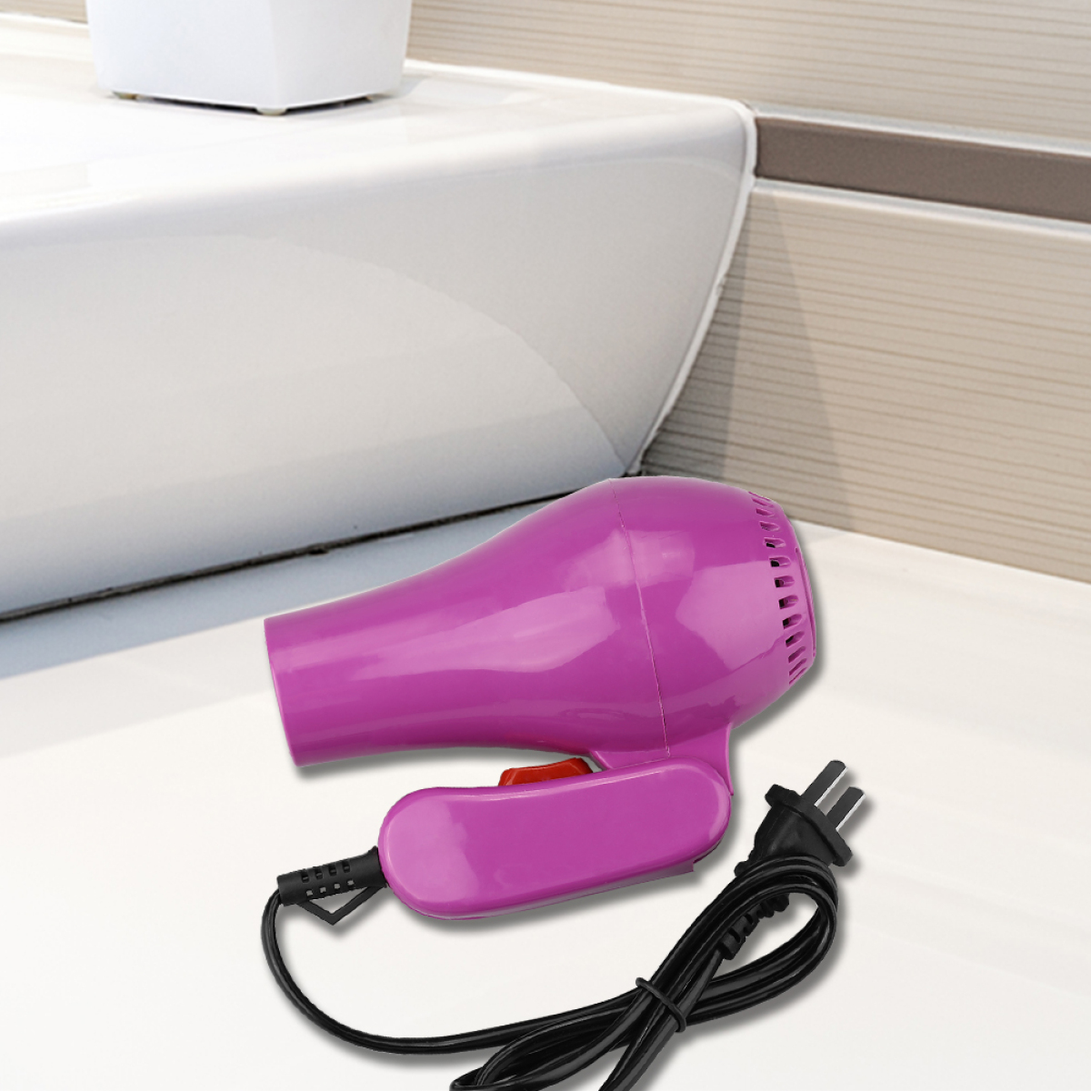 Ein pinkfarbener Haartrockner mit schwarzem Netzkabel und Stecker, platziert auf einer weißen Oberfläche neben einem weißen Waschbecken.