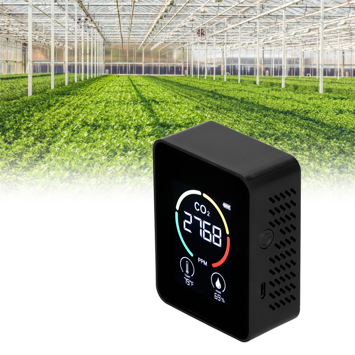 Schwarzer CO2-Monitor zeigt Messwerte an. Der Hintergrund ist ein Gewächshaus.