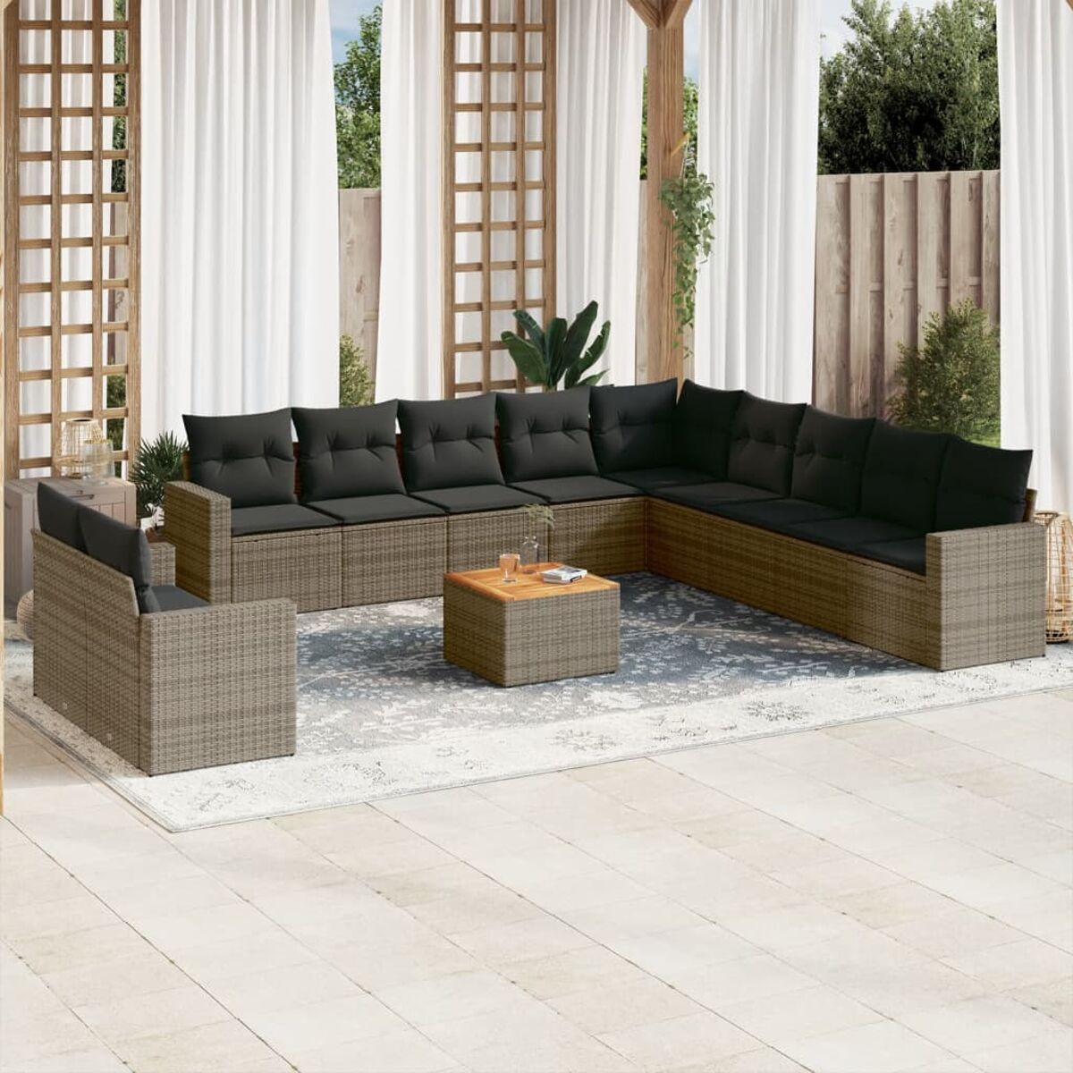 Eine Terrassengarnitur mit einem großen Ecksofa, einem Stuhl und einem Couchtisch auf einem gemusterten Teppich.