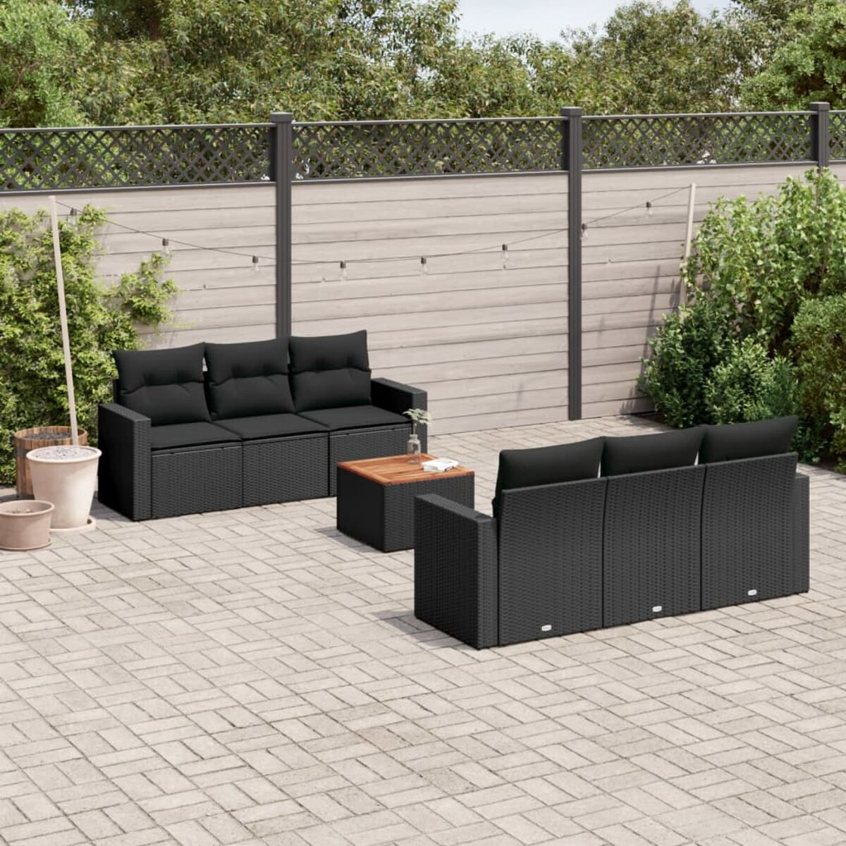 Un set da patio esterno nero, con un divano, due sedie e un tavolino su un patio.
