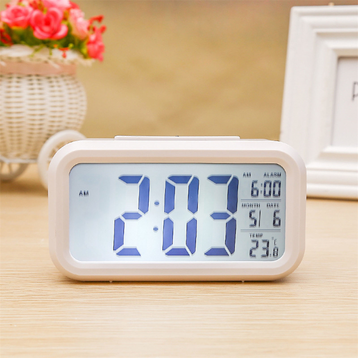 Weißer digitaler Wecker, der Uhrzeit, Datum, Temperatur und Alarmeinstellungen anzeigt.