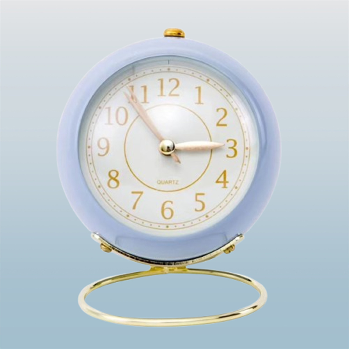 Blauer Wecker mit weißem Zifferblatt und goldenen Akzenten. Die Uhr steht auf einem goldenen Ständer.