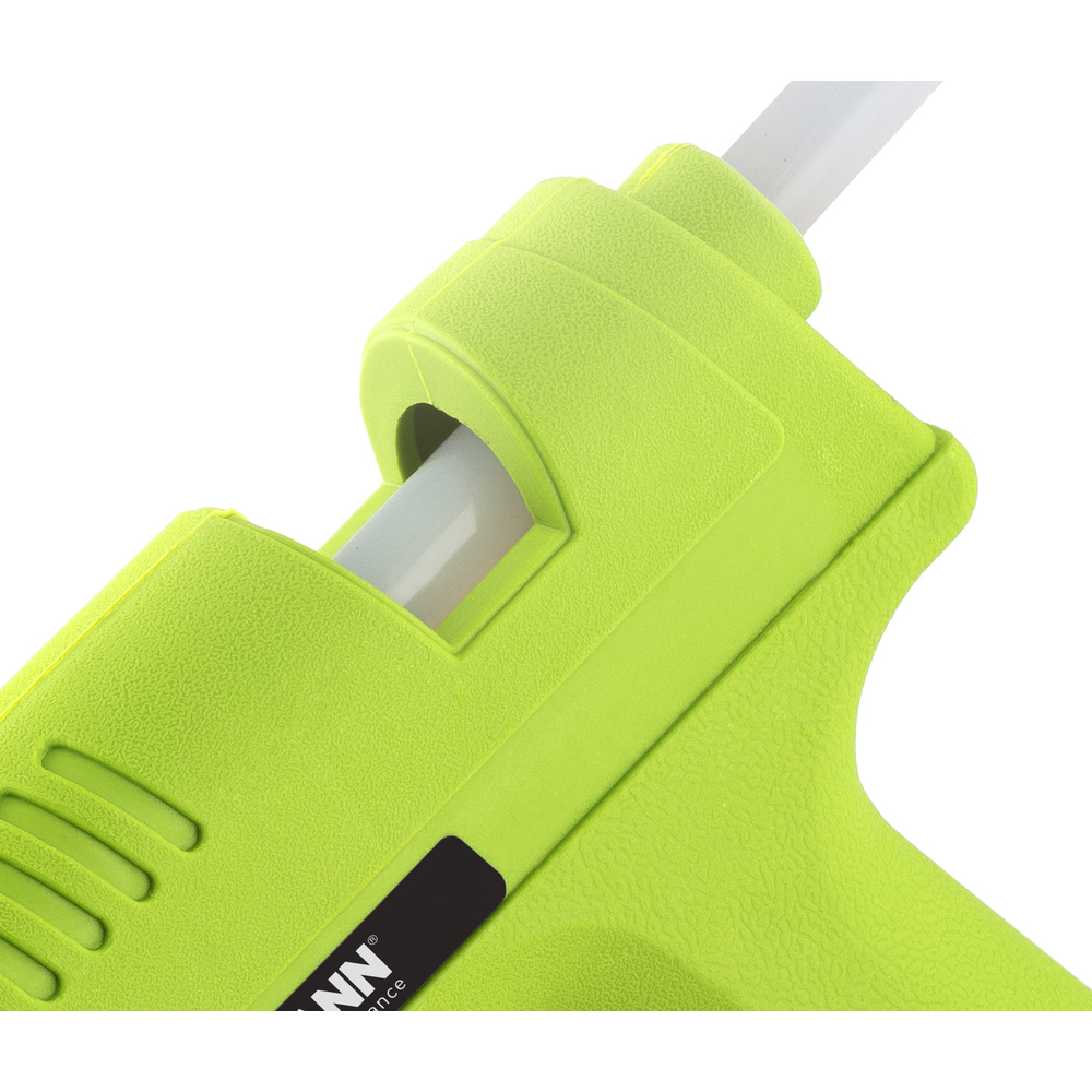 Primo piano di una pistola per colla verde con stick di colla bianco inserito.
