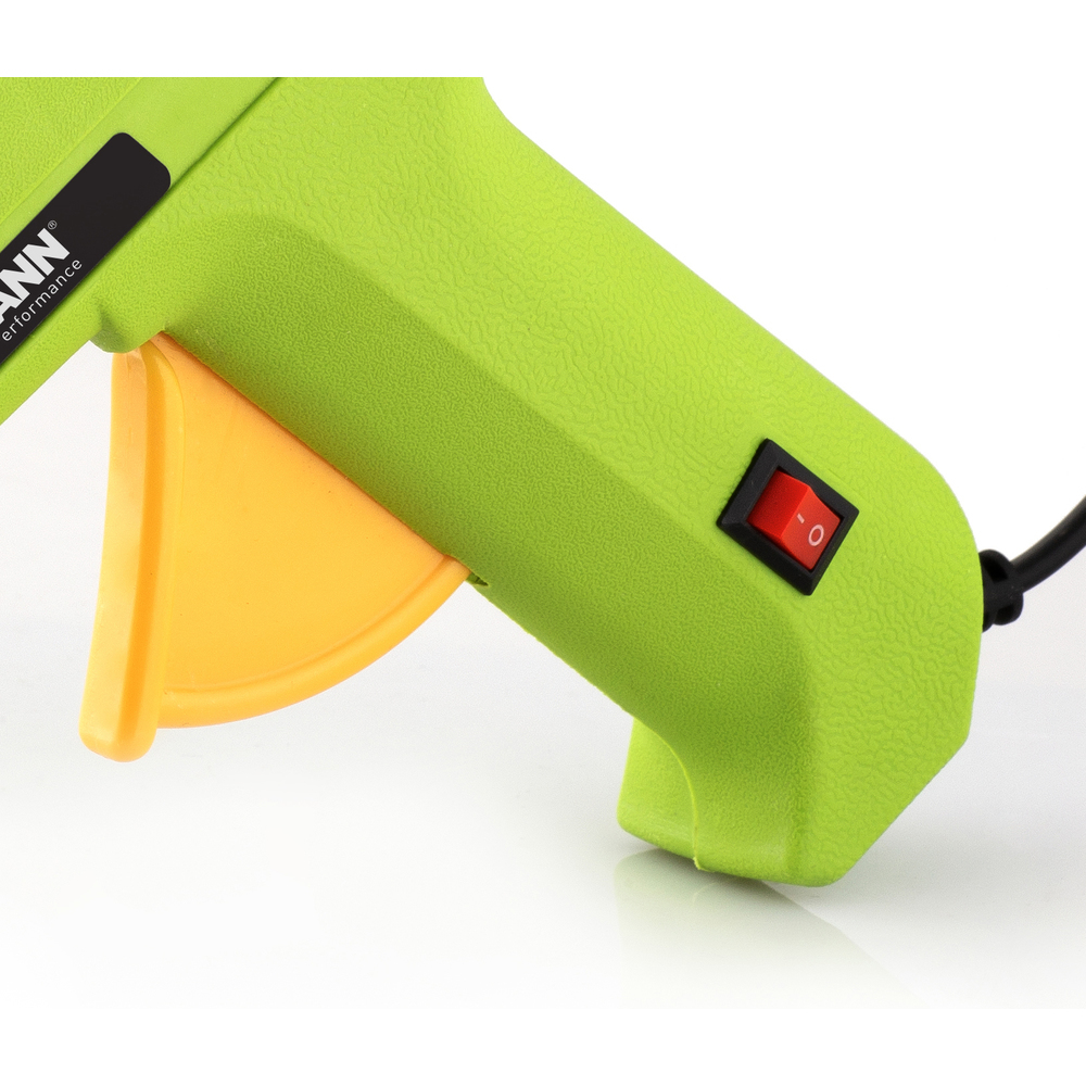 Primo piano di una pistola per colla verde con grilletto giallo e interruttore rosso on/off.