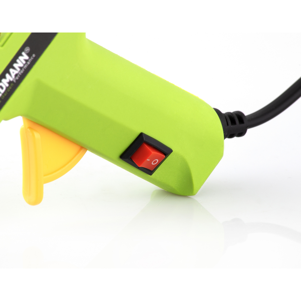 Primo piano di una pistola per colla verde con interruttore rosso e grilletto giallo.