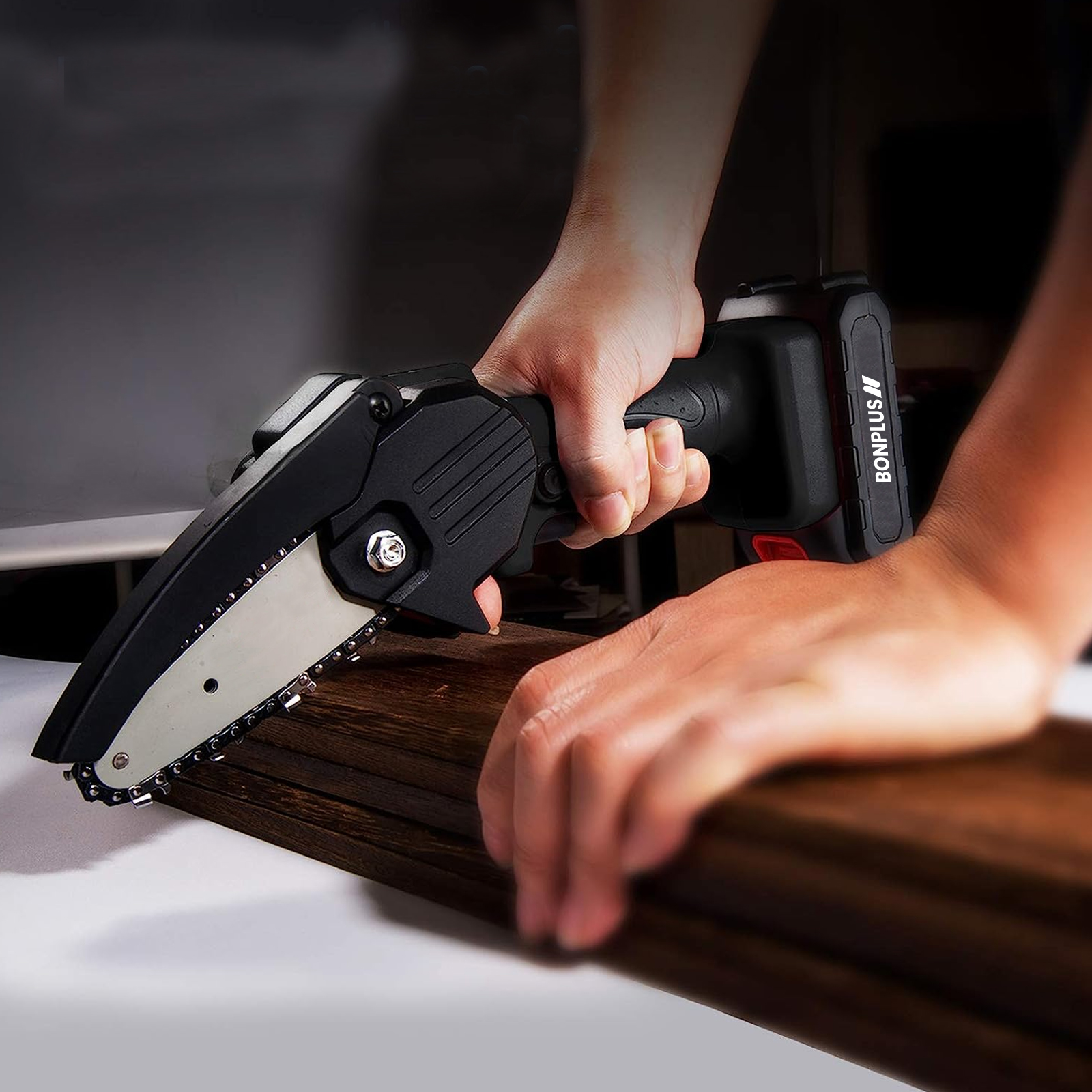 Una persona usa una mini motosierra eléctrica Bonplus sobre una superficie de madera.