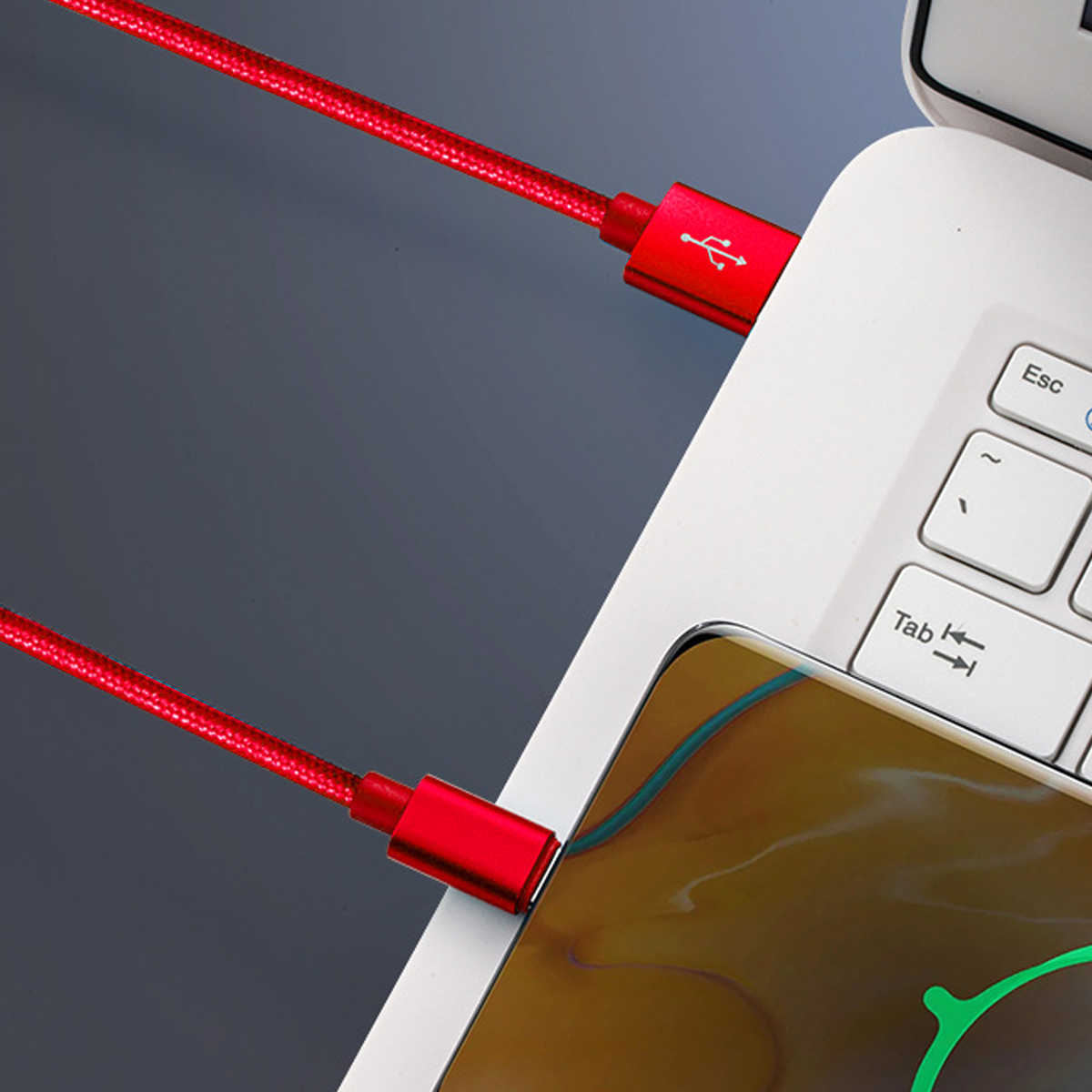 Rotes USB-Ladekabel an Laptop und Telefon angeschlossen.